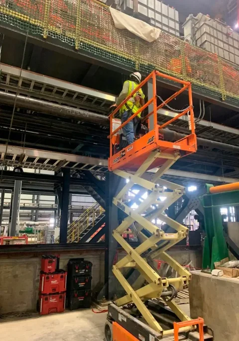 Worker on a lift completing high altitude electrical work